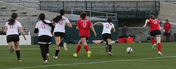 Players in red and white Sisterhood jerseys chasing the ball during the exhibition match