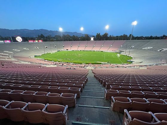 View from the Rose Bowl stands at twilight looking down at the lit field below