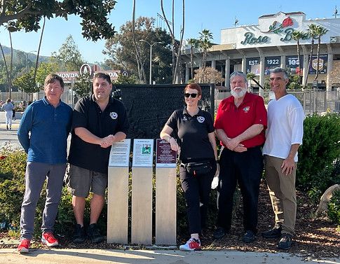 Five adults posing in front of a Rose Bowl plaque