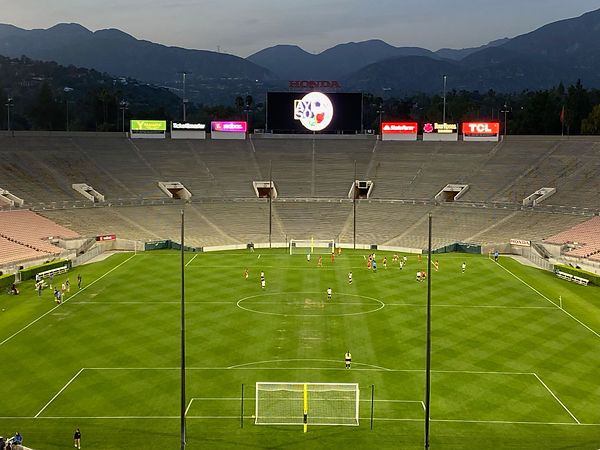 Wide view of the exhibition match at the Rose Bowl with the AYSO logo on the jumbotron